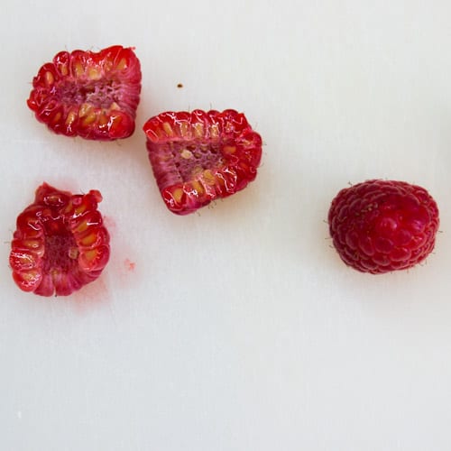 Demonstrating a cut in half lengthwise raspberry