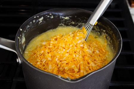Shredded colby jack cheese added to cooked polenta