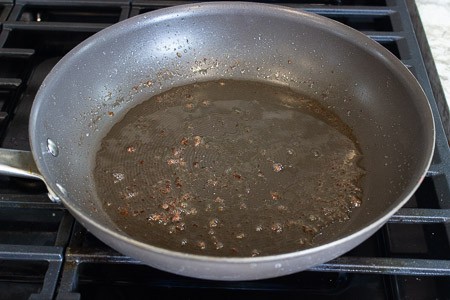 A coating of grease from the sausage left in the pan to cook the veggies in