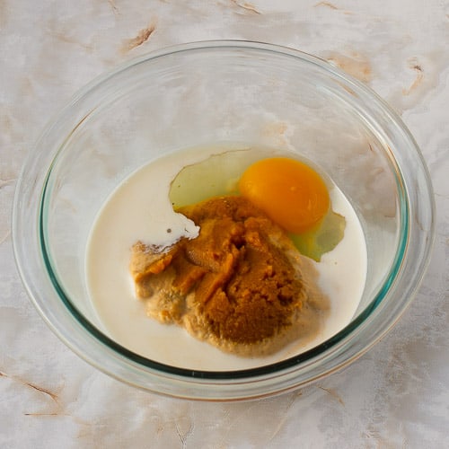 the wet ingredients for pumpkin walnut scones in a bowl