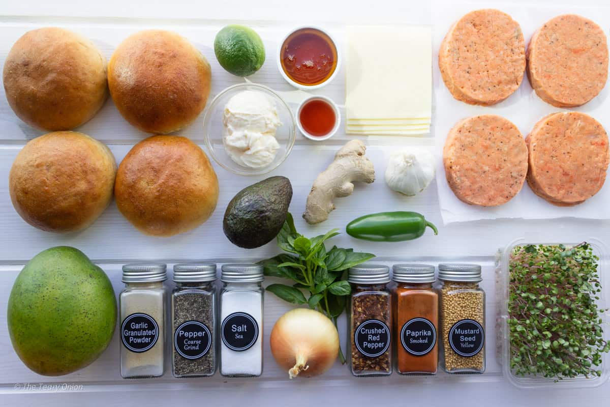 Ingredients for gourmet salmon burgers with mango chutney on a white board background.