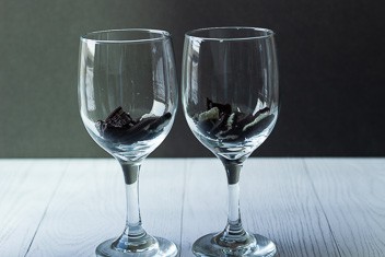 two wine glasses with broken oreos inthe bottom