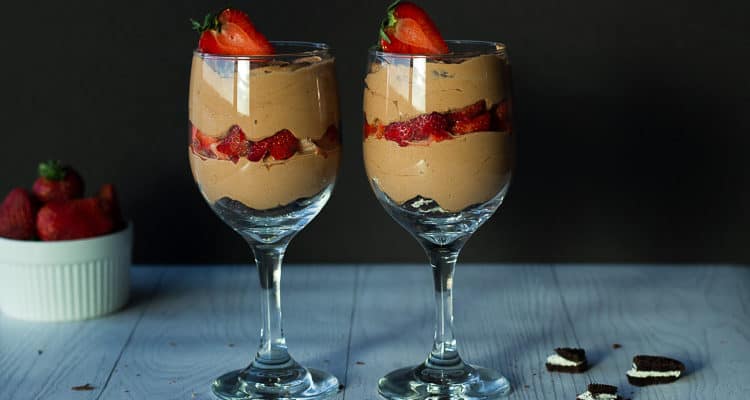 layers of oreos chocolate mousse and strawberries in wine glasses
