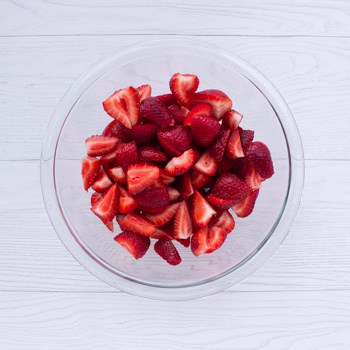 quartered strawberries in a clear glass bowl