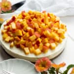 a whole no bake cheesecake with diced peaches on top