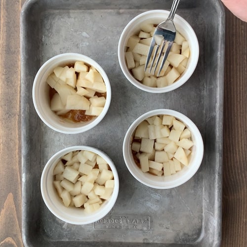 diced pears in four ramekins over melted butter and brown sugar