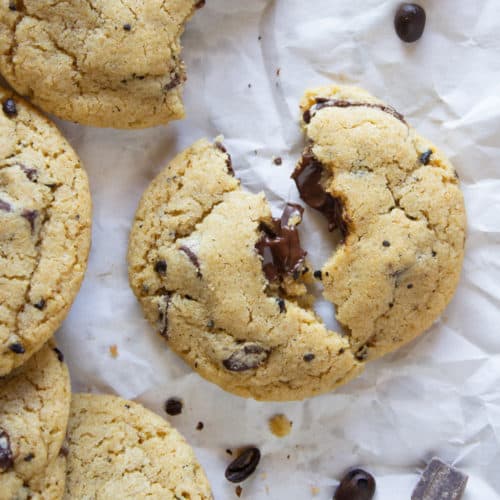 coffee chocolate chunk cookies on a crinkled white paper one cookie is broken in half