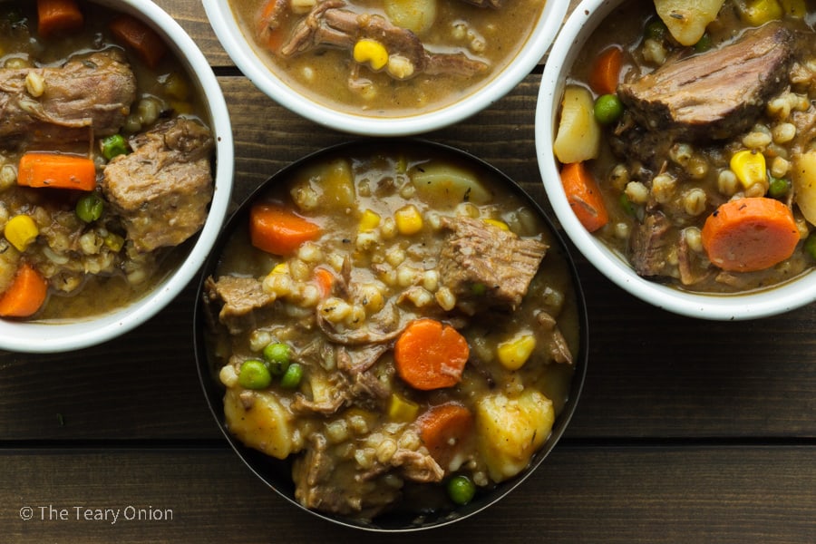 up close top view of four bowls of slow cooked beef stew with barley