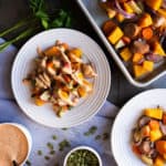 butternut squash bake on a plate drizzled with dressing and sprinkled with pumpkin seeds