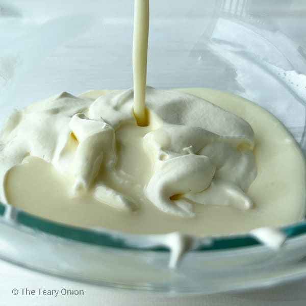 pouring white chocolate into whipped cream