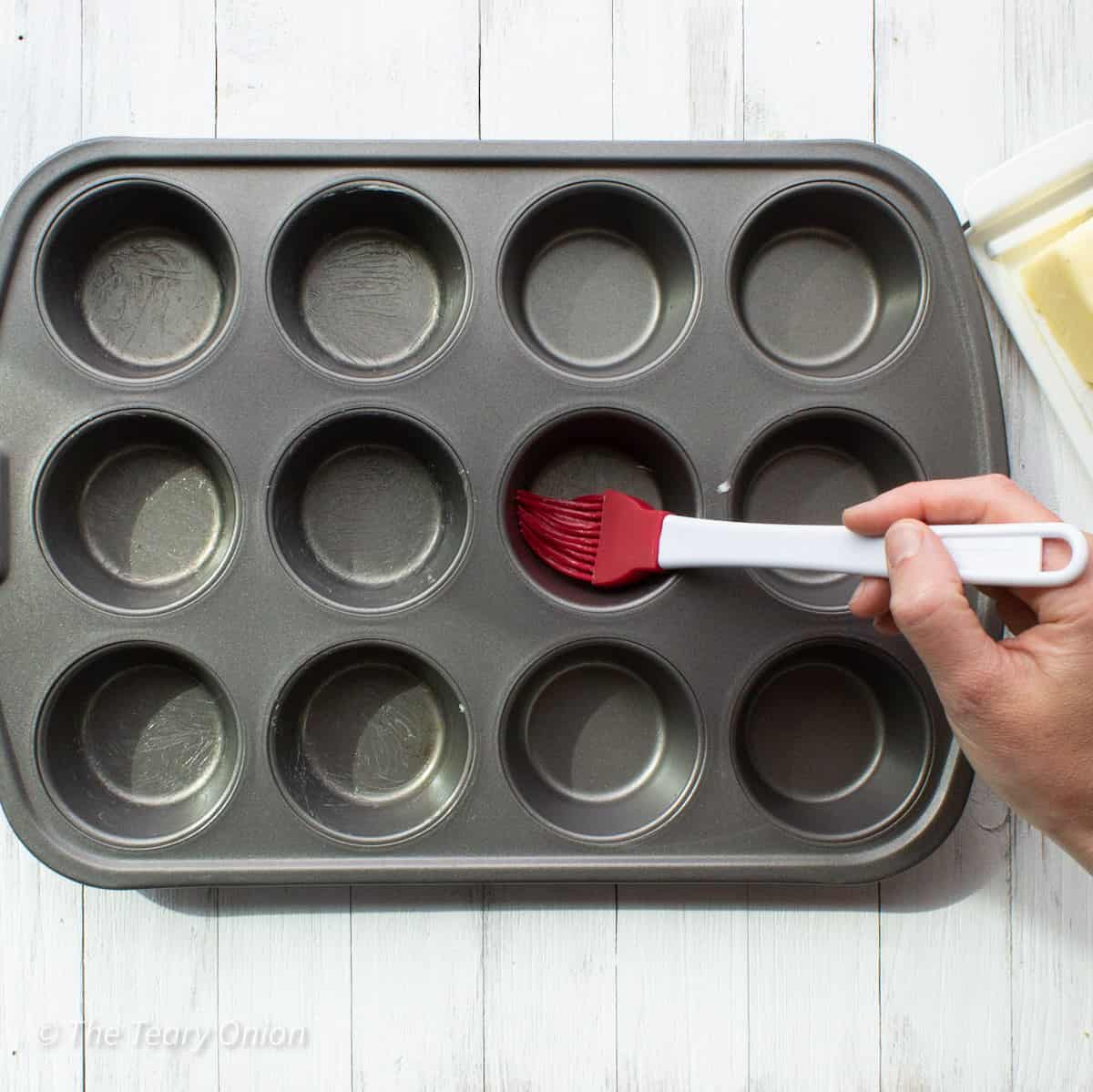 buttering a muffin tin.