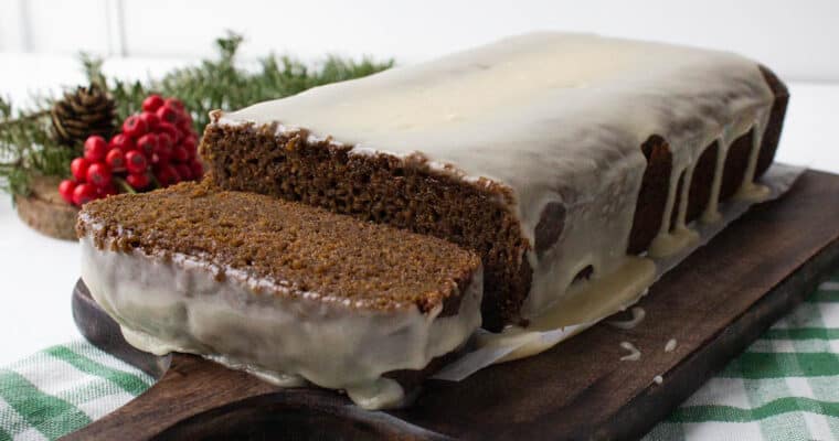 Glazed gingerbread loaf cake with 1 slice off the end.