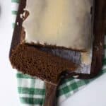Iced gingerbread loaf with a slice off the end and a bite taken out of the slice.