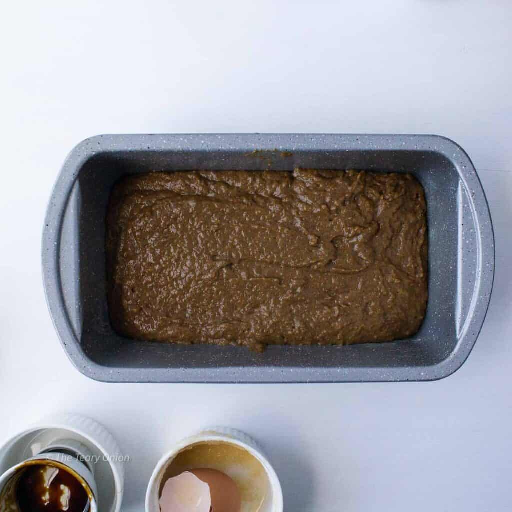 Gingerbread cake batter in a loaf pan.